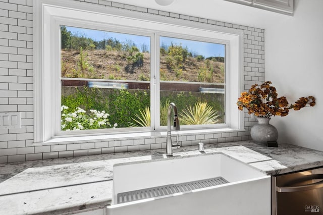 room details with light stone counters, dishwasher, and sink