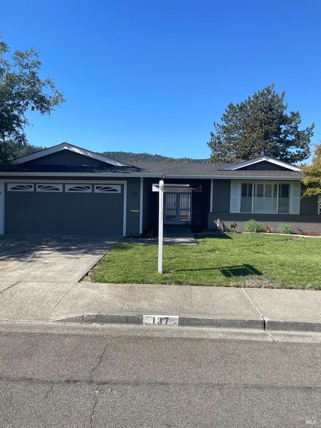 ranch-style house featuring a front lawn and a garage