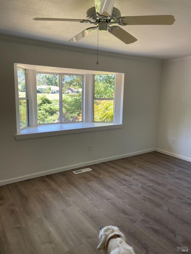 unfurnished room featuring a textured ceiling, ornamental molding, dark hardwood / wood-style flooring, and ceiling fan