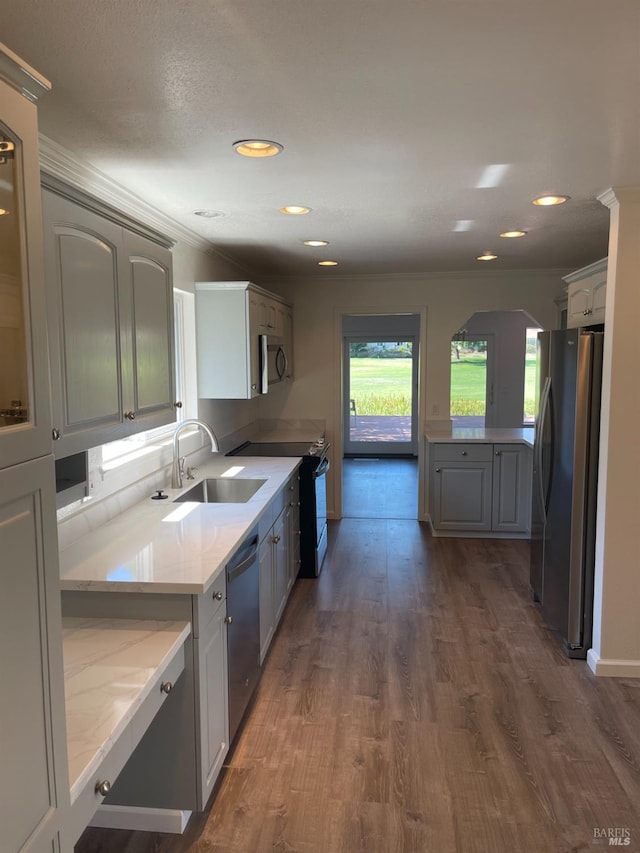 kitchen with dark wood-type flooring, a sink, appliances with stainless steel finishes, and arched walkways