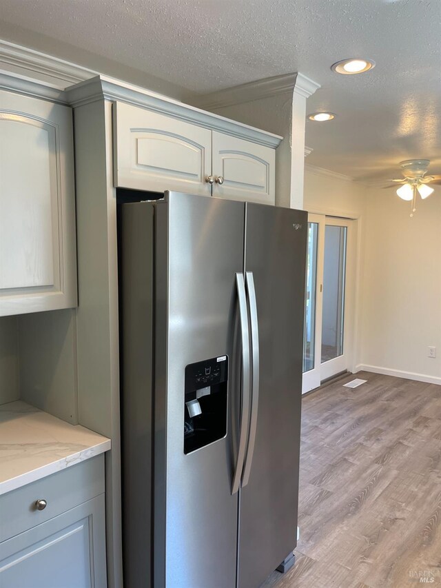 kitchen with light wood-style floors, crown molding, ceiling fan, and stainless steel fridge with ice dispenser