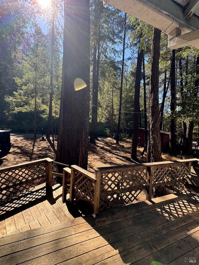 wooden terrace featuring a view of trees