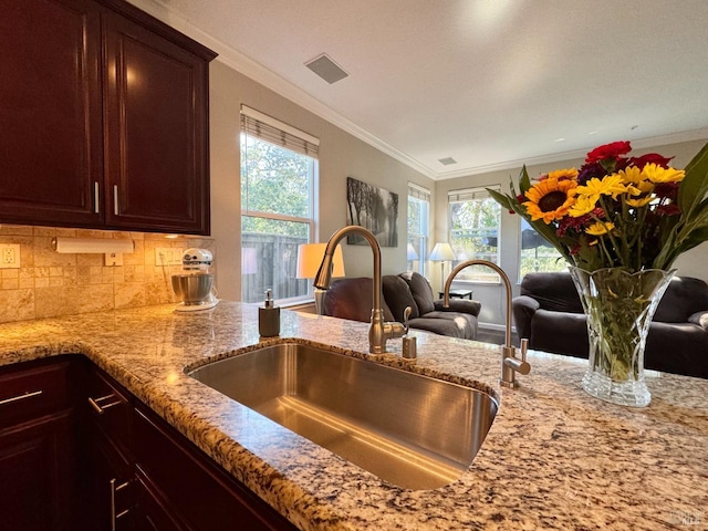 kitchen with tasteful backsplash, crown molding, and sink