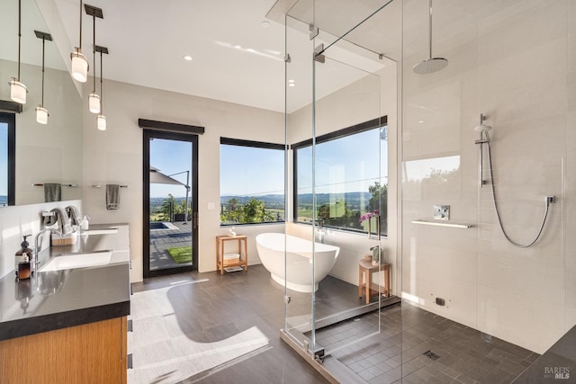 full bathroom with a sink, a shower stall, tile patterned flooring, a freestanding bath, and double vanity