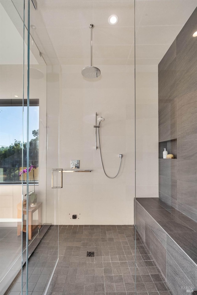 bathroom with tile walls and a shower stall