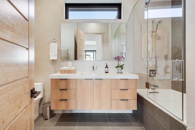 bathroom with tiled shower / bath combo, toilet, tile walls, and a wealth of natural light