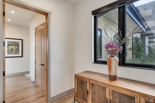 hall with baseboards, recessed lighting, and light wood-type flooring