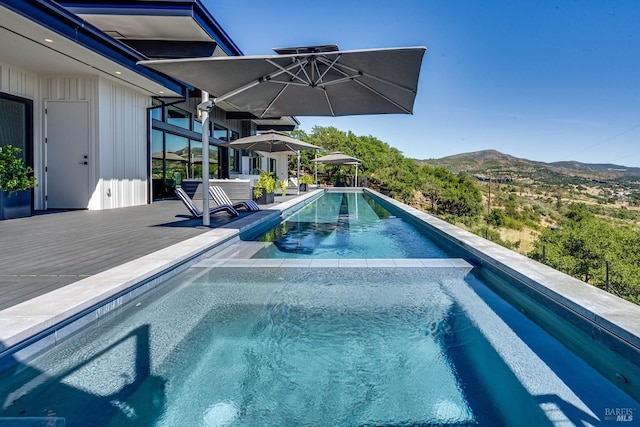 outdoor pool featuring a patio area and a mountain view