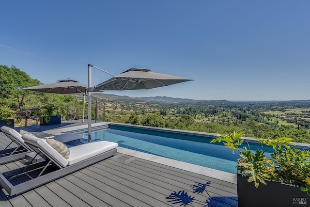 pool with a deck with mountain view and a forest view