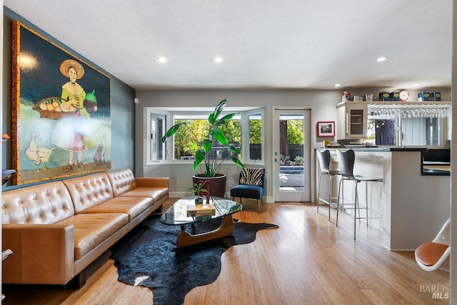 living area featuring recessed lighting, baseboards, a textured ceiling, and wood finished floors