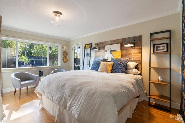 bedroom with wood finished floors, baseboards, and ornamental molding