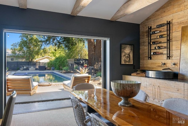 dining area featuring vaulted ceiling with beams