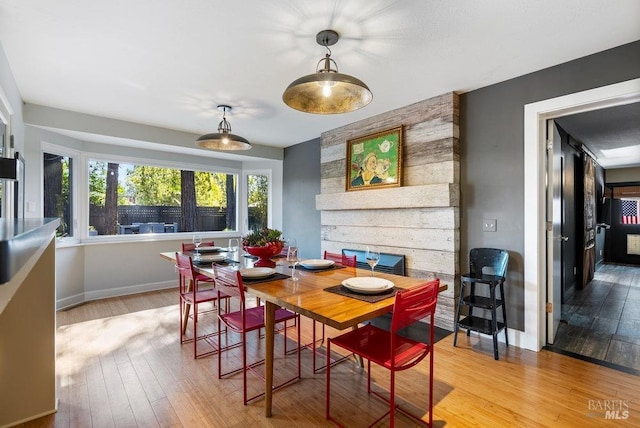 dining area featuring baseboards and light wood-style floors