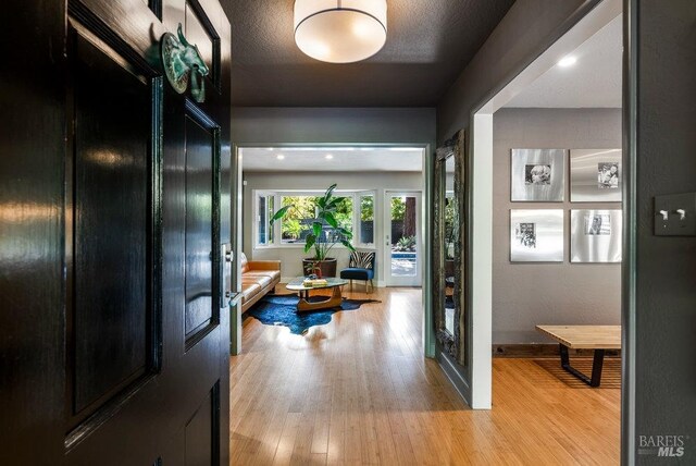 living room featuring a notable chandelier, light hardwood / wood-style flooring, and wood walls