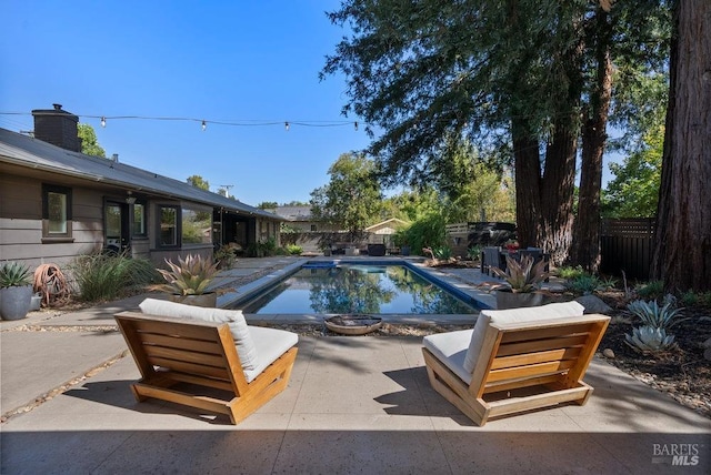 view of swimming pool featuring a patio area, a fenced in pool, and a fenced backyard