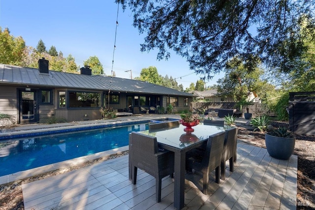 outdoor pool with outdoor dining space and fence