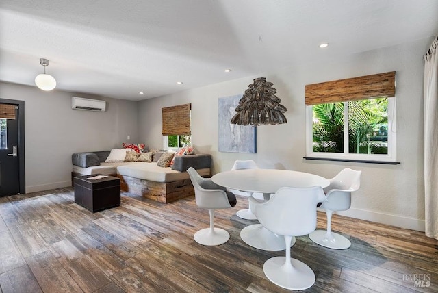 living room featuring an AC wall unit, hardwood / wood-style flooring, recessed lighting, and baseboards