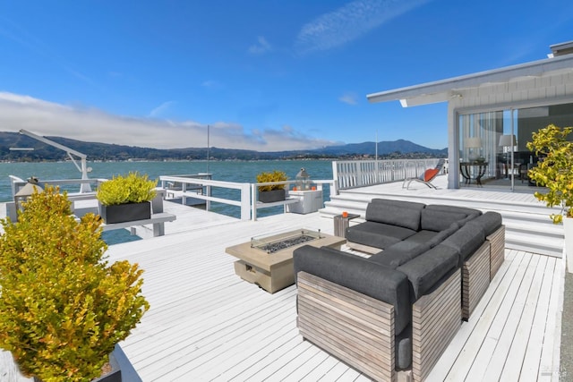 deck featuring a water and mountain view and an outdoor fire pit