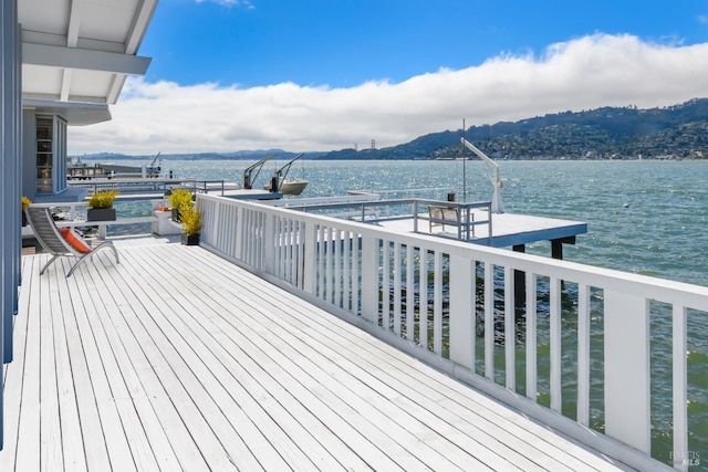 wooden terrace featuring a water and mountain view