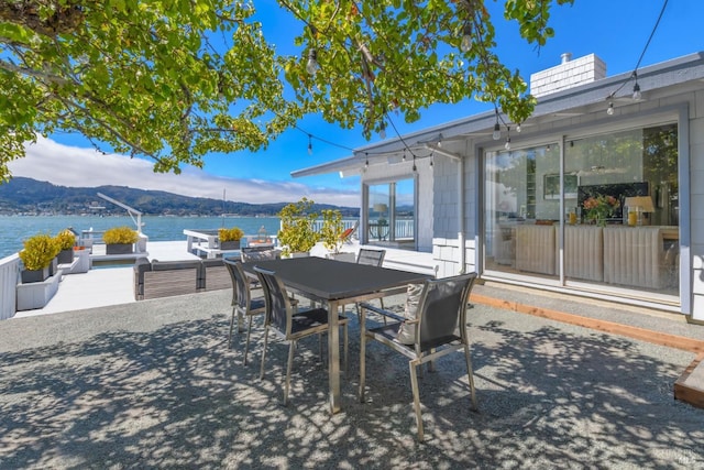 view of patio / terrace featuring a water and mountain view