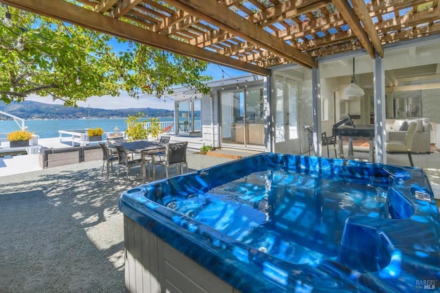 view of patio with a pergola, a water view, and a hot tub