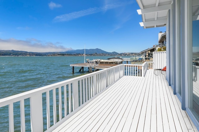 deck with a boat dock and a water and mountain view