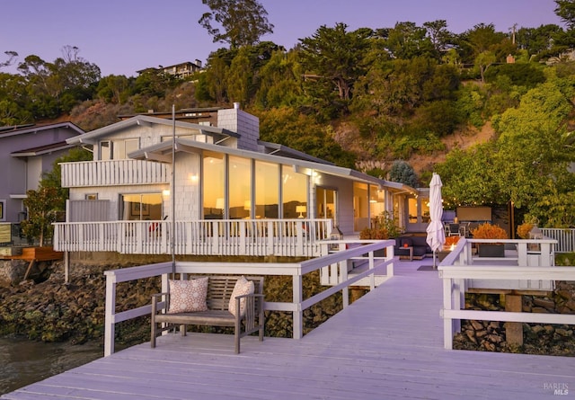 back house at dusk with a deck