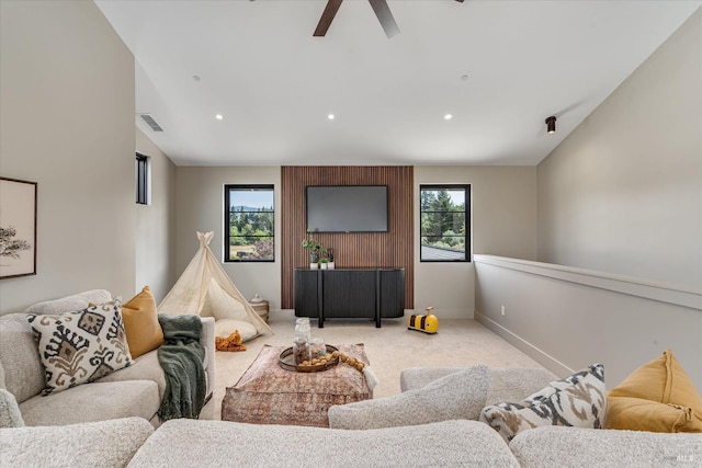 living room featuring ceiling fan, plenty of natural light, and light colored carpet