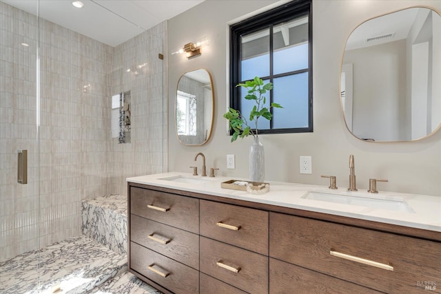 bathroom featuring vanity and a shower with shower door