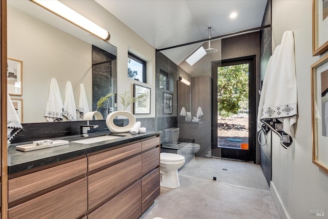 bathroom with vanity, a shower, tile walls, concrete floors, and toilet