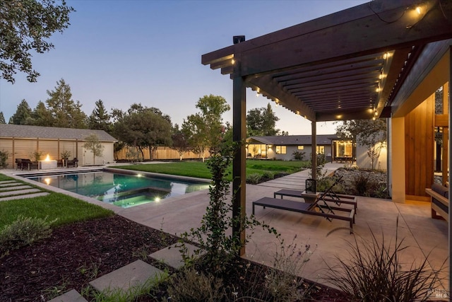 pool at dusk featuring a yard, a pergola, an in ground hot tub, and a patio