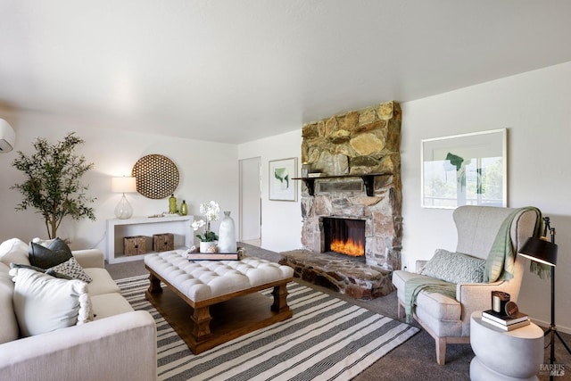 living room with carpet flooring, a stone fireplace, and a wall mounted AC