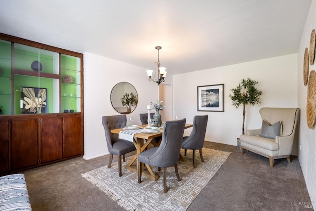 dining area featuring a chandelier and dark carpet