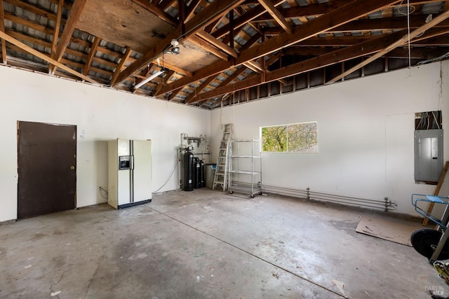 garage with white refrigerator with ice dispenser and electric panel