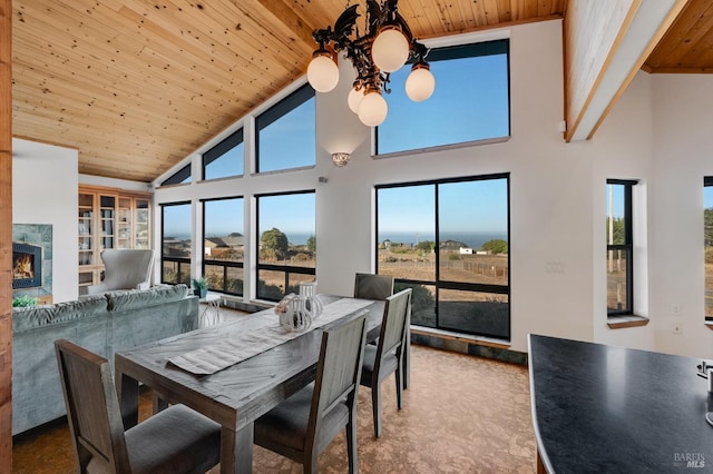 dining area with a high ceiling, a warm lit fireplace, and wooden ceiling