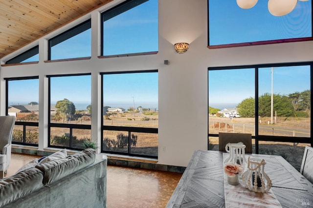 living area featuring concrete floors, high vaulted ceiling, and wood ceiling
