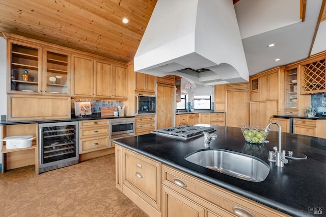 kitchen featuring appliances with stainless steel finishes, lofted ceiling, beverage cooler, custom exhaust hood, and sink