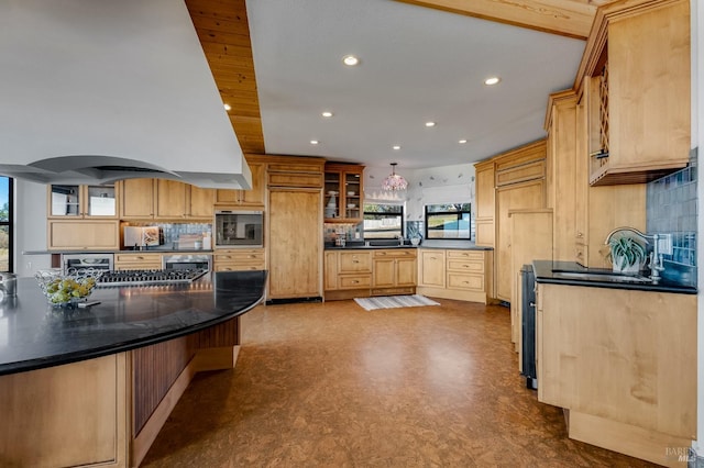 kitchen featuring decorative backsplash, island range hood, oven, decorative light fixtures, and sink