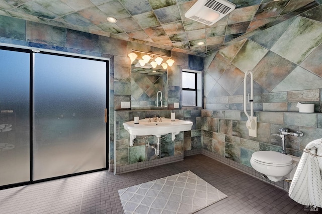 bathroom with tile walls, tile patterned flooring, and toilet