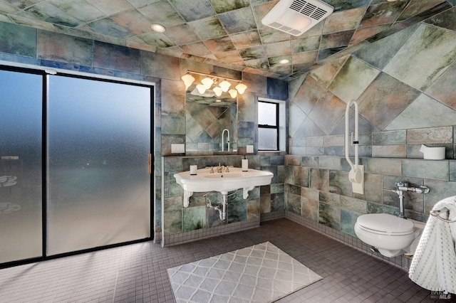 bathroom with tile patterned floors, toilet, tile walls, and visible vents