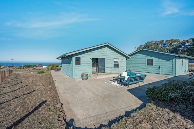 back of property with an outdoor hangout area, fence, and a patio area
