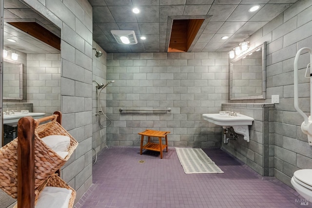 full bathroom featuring tile walls, a tile shower, recessed lighting, toilet, and tile patterned floors
