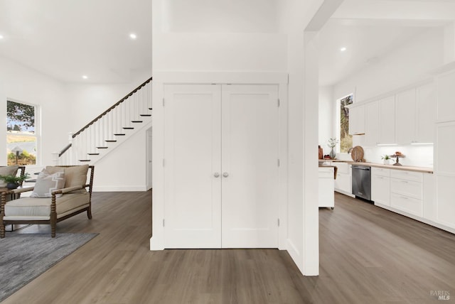 entryway with recessed lighting, wood finished floors, and stairs