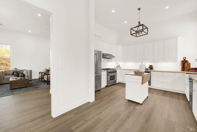 kitchen with light wood-type flooring, premium appliances, butcher block countertops, and white cabinetry