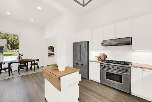 kitchen with backsplash, high quality appliances, dark hardwood / wood-style floors, white cabinetry, and butcher block counters