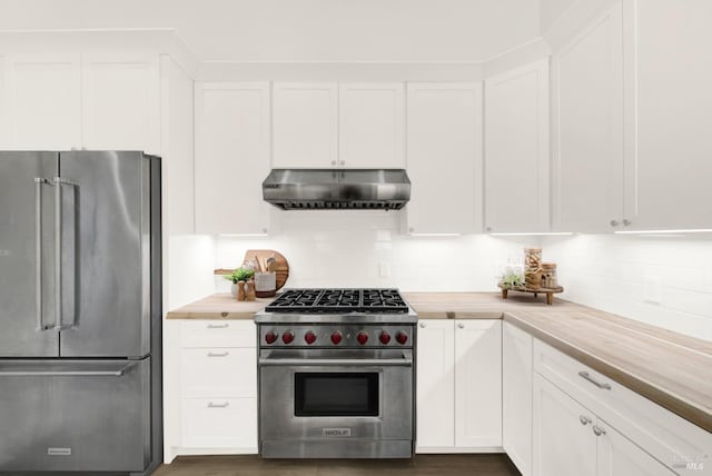 kitchen featuring tasteful backsplash, white cabinetry, wooden counters, and premium appliances