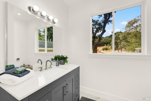 bathroom featuring tile patterned flooring, vanity, and a healthy amount of sunlight