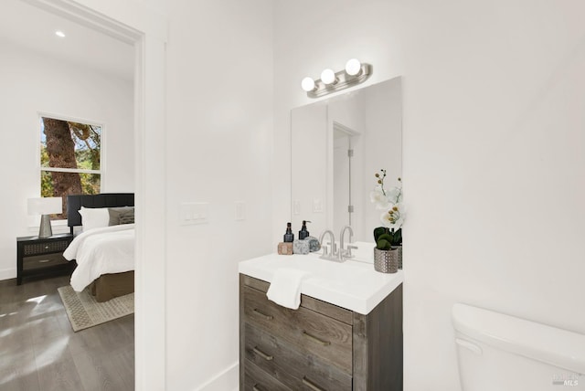 bathroom featuring toilet, vanity, and hardwood / wood-style flooring