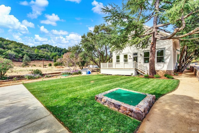 view of yard featuring an outdoor structure and a wooden deck