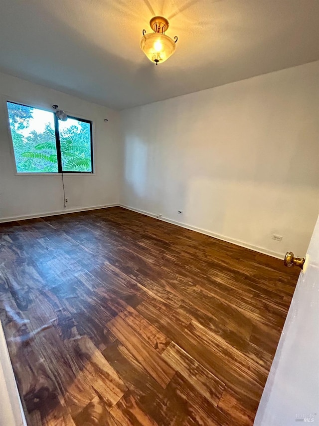 unfurnished room with dark hardwood / wood-style floors